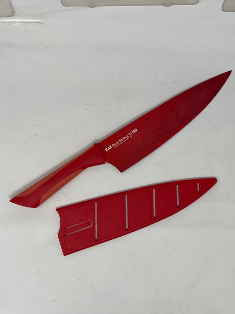 KAI Pure Komachi HD coated carbon stainless steel chef knife with a silicone-lined handle, shown alongside its original hard case for secure storage.