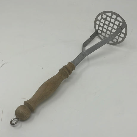 Potato masher with wood handle and metal ring attachment for easy storage.