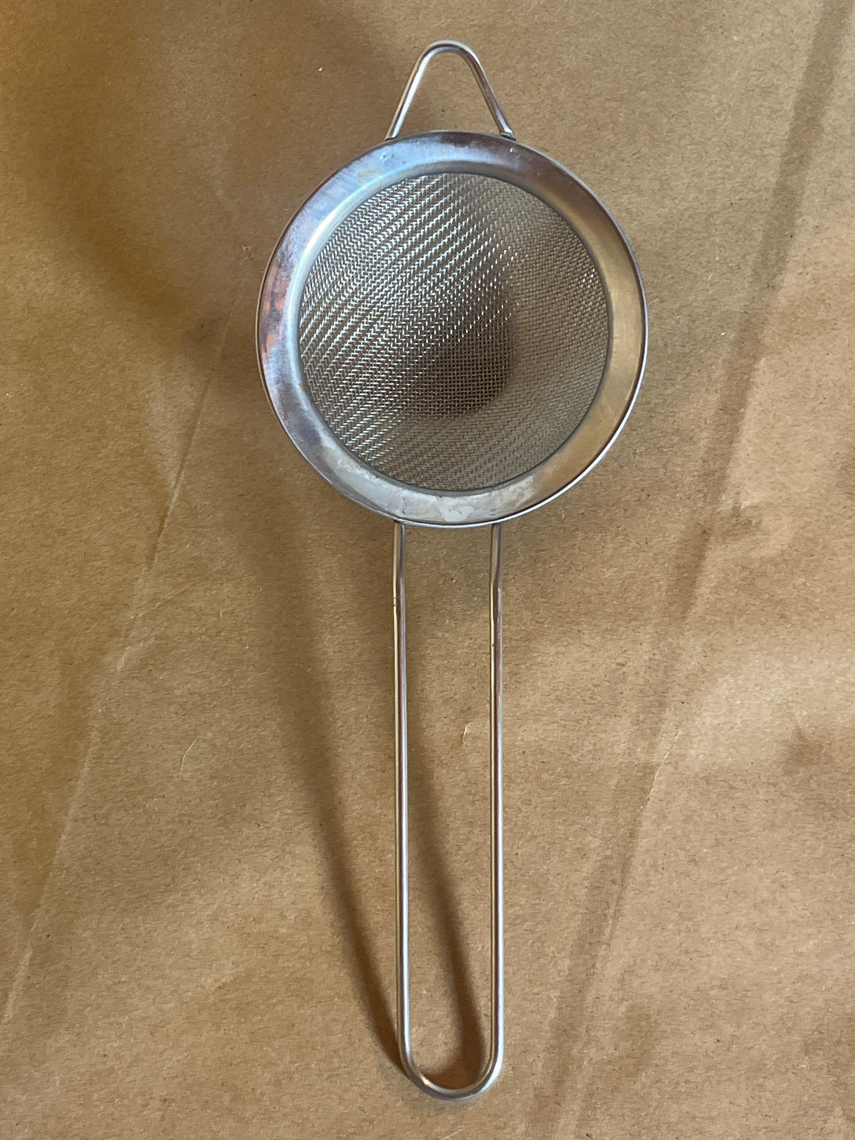 Stainless steel mesh strainer with loop handle, 2.5 inch, ideal for sifting and straining. Features a hanging ear for convenient cup or bowl placement.