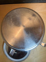 Stainless steel food storage container with clasps, handle, and silicone seal, showing its lid slightly ajar, highlighting the sturdy, leakproof design for versatile storage.