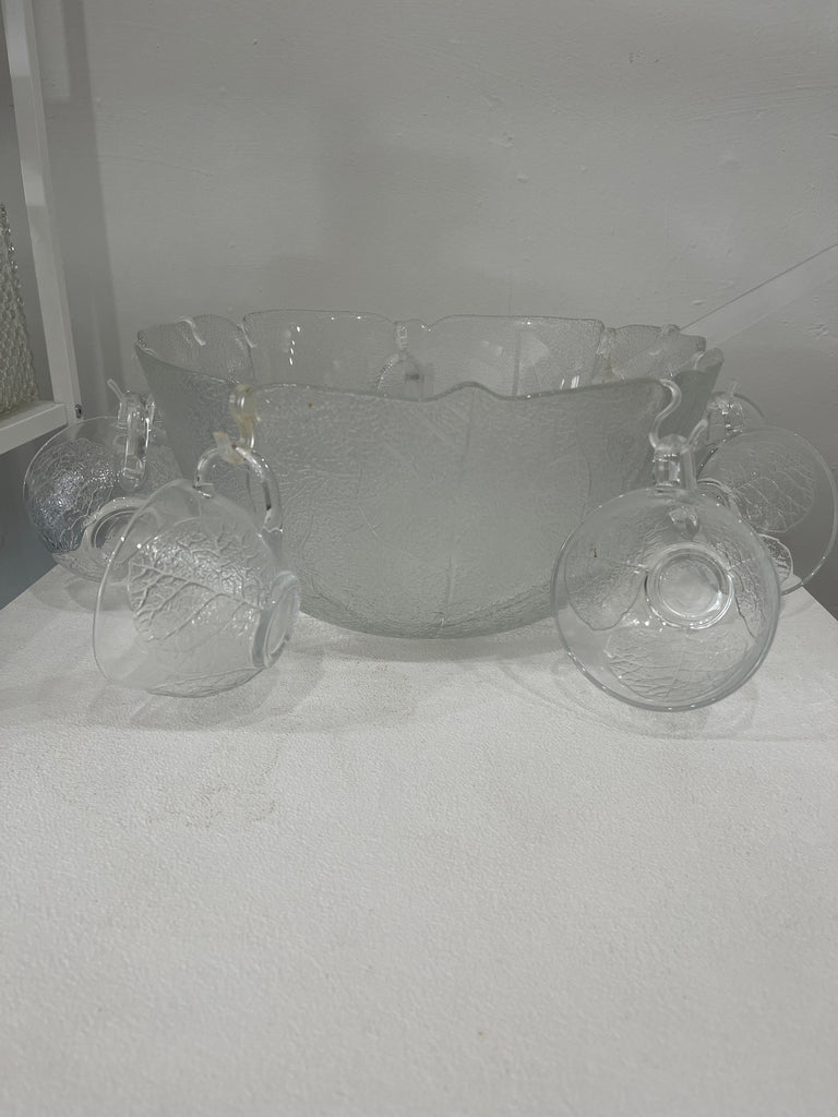 Punch bowl set with leaf pattern embossment, featuring a glass bowl and cups on a table, perfect for garden parties. Includes 12 cups and a ladle.