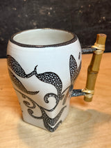 Hand-crafted ceramic mug with a black bubbled-dot pattern and bamboo handle, part of an 8-piece set with a floral-patterned sugar bowl featuring bamboo handles.
