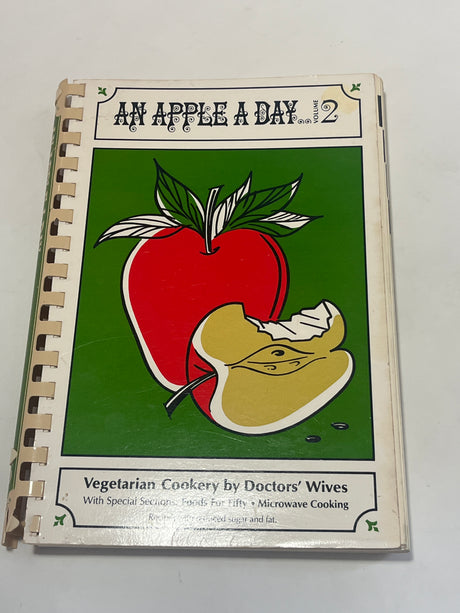 Cover of RARE An Apple a Day Volume Two – Vegetarian Cookery by Doctors' Wives featuring special sections on Foods for Fifty and Microwave Cooking.