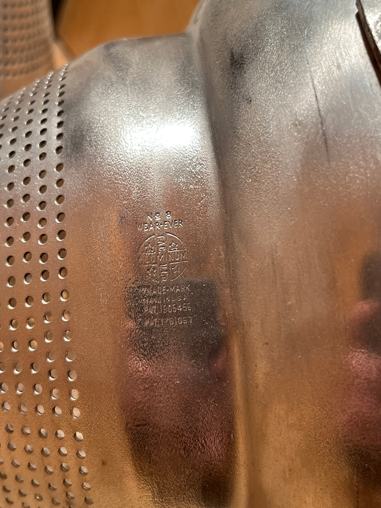 Close-up of Tiny pointy cone sieve strainer - aluminum, showing perforated holes, “Wear-Ever Aluminum” stamp, and patent numbers. Handle securely attached; slight cone tip dent visible.