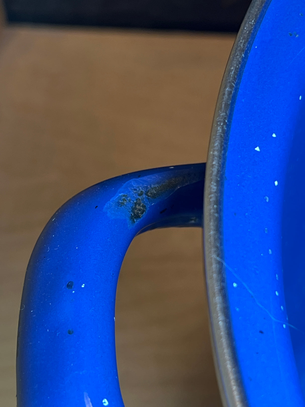 Marlboro Gear 6 quart stock pot, blue speckled enamelware, showing chipped enamel exposing rust at handle joint. Stray fiber visible on rim.
