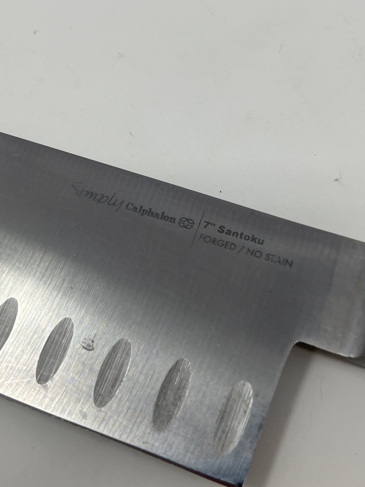 Simply Calphalon 7” Santoku knife, ideal for chopping crispy produce and herbs, displayed with a sharp blade and ergonomic handle.