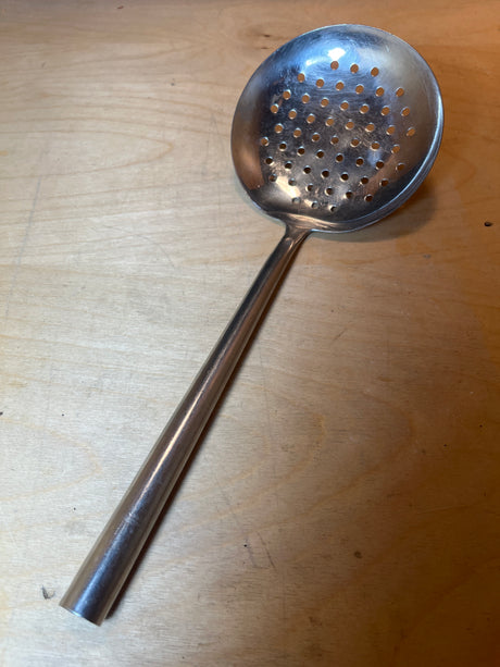 Round skimmer spoon - stainless steel with a perforated ladle and long, angled handle, ideal for draining blanched vegetables and skimming soups.