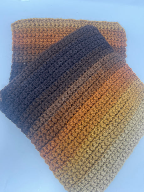 Retro hand-crocheted brown striped potholders set of 2, showcasing a chunky texture, displayed on a blue surface.