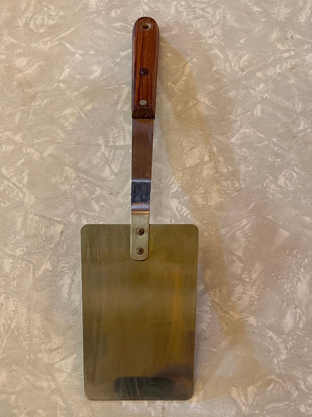 Flat thin steel spatula with wood handle - vintage, featuring a stainless steel blade and angled wooden handle, ideal for flipping pancakes and grilling veggie burgers.