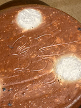 Handmade ceramic garlic grater spoon rest by Charles Lehman, showing the underside with two unglazed stilt marks and the potter's signature.