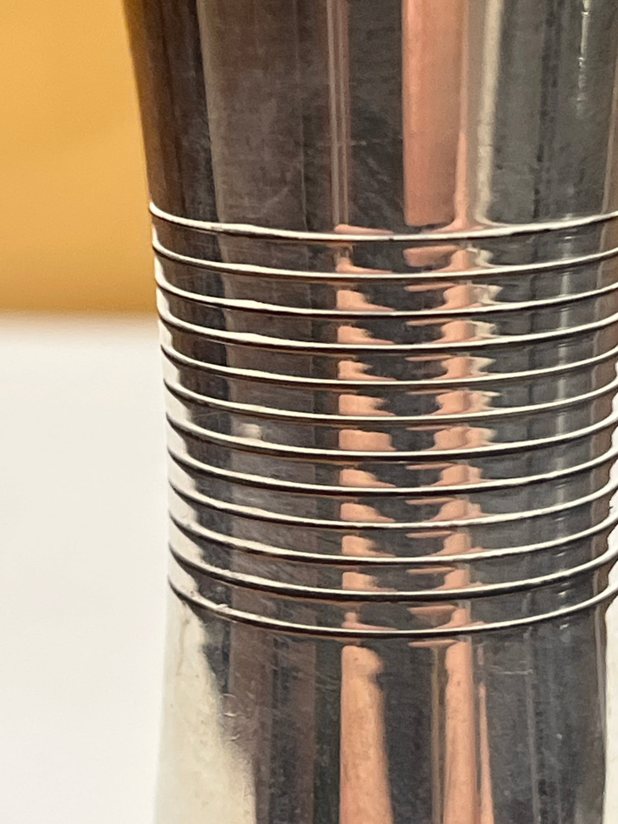 Towle sterling silver jigger shot glass with a sleek midcentury design, featuring small dents on the edges, enhancing its vintage charm.