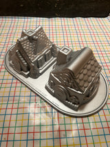Gingerbread House Duet cast aluminum baking pan mold by Nordicware, showcasing two intricate house shapes, ideal for uniform baking with nonstick, PFAS-free coating.