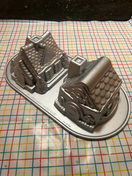 Gingerbread House Duet cast aluminum baking pan mold by Nordicware, showcasing two intricate house shapes, ideal for uniform baking with nonstick, PFAS-free coating.