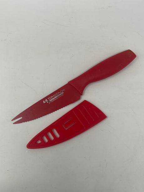Hampton Forge Tomodachi serrated tomato/cheese knife with plastic case, showcasing its sharp, durable blade ideal for slicing tomatoes and vegan cheese; includes storage case.