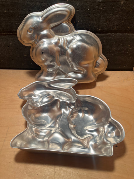 Bunny rabbit 2-piece baking mold showing two aluminum halves shaped like a vintage-style bunny, open on a wooden surface.