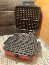 Red vintage Wards Signature BE-46029 waffle iron, open to show grid-patterned plates for Belgian waffles; tested, adjustable temperature, avoid harsh cleaners to maintain paint.