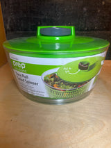 Easy Pull Salad Spinner by Prep Solutions featuring a clear outer bowl, green spinner basket, and lid with pull-cord mechanism for quick, efficient salad drying.