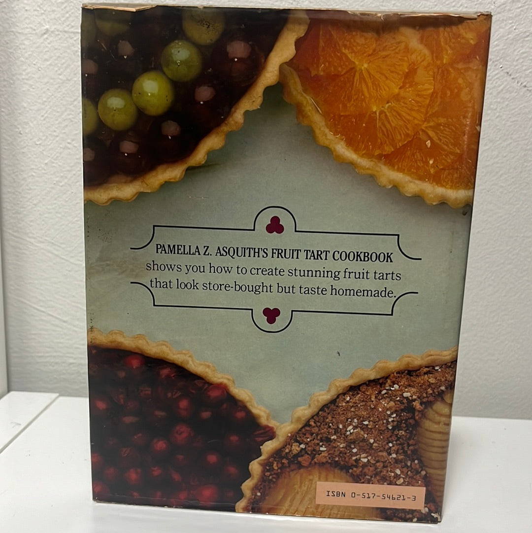 Pamella Z. Asquith's Fruit Tart Cookbook on a shelf, featuring a cover image of a fruit tart, highlighting dessert recipes and techniques.