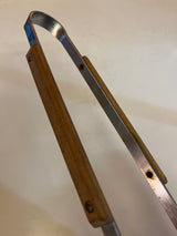 Vintage grill tongs with wood handle featuring metal arms and a spring-style loop for easy operation, ideal for kitchen and serving tasks.