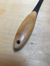 Wolfgang Puck stainless steel perforated spatula with bamboo handle, showcasing a thin metal blade, rounded wooden handle with hanging hole, and engraved logo.