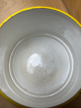 Overhead view of a vintage Michael Lax Copco fondue pot with a yellow enamel rim, showing light interior staining and a small chip on the rim.