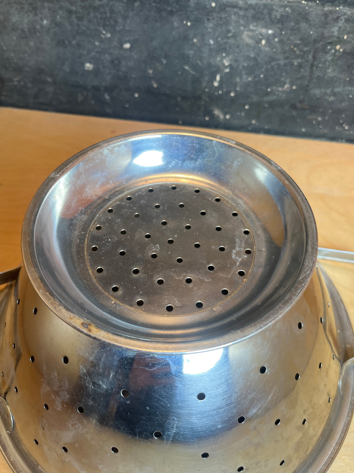 Colander - vintage stainless steel: A small, perforated stainless-steel colander with geometric angles, featuring a handle, ideal for draining pasta or steaming vegetables.