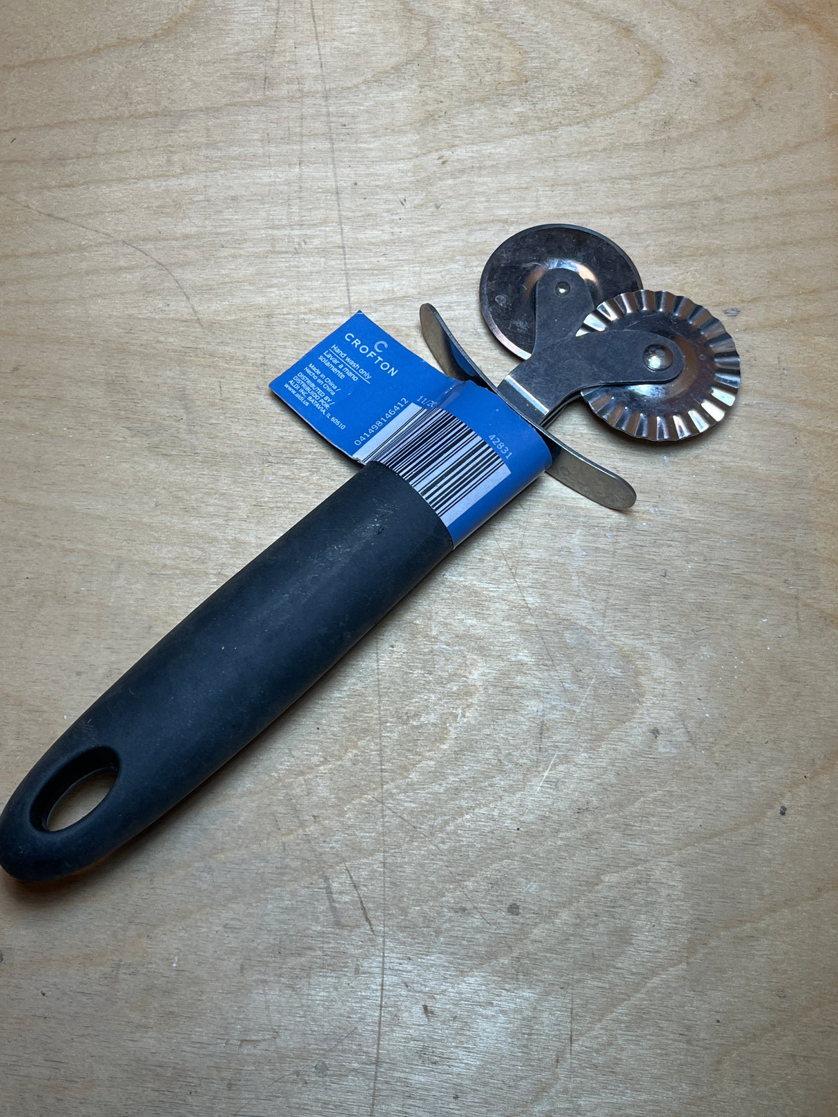 Dual pastry cutter with soft grip black handle from Crofton, featuring smooth and fluted wheels for versatile cutting of pastry, ravioli, and pizza.