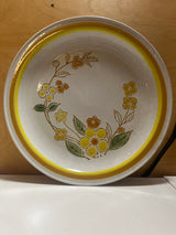 Sunny speckled floral serving plate featuring a ceramic design with a yellow floral motif, gold and orange rim, and painted leaves from International China’s Country Meadow line.