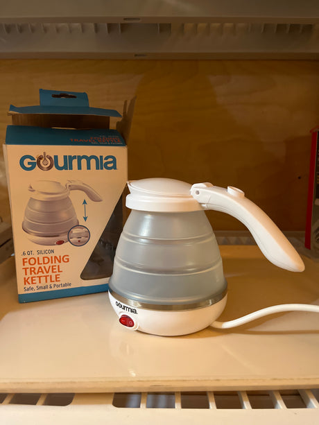 Gourmia folding travel kettle with a silicone base and stainless steel heating element, designed to boil up to 0.6 qt of water quickly.