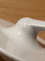 Dough hook attachment for Kitchenaid stand mixer, shown as a white glazed ceramic spoon rest with a central hump stamped “32” for utensil placement.