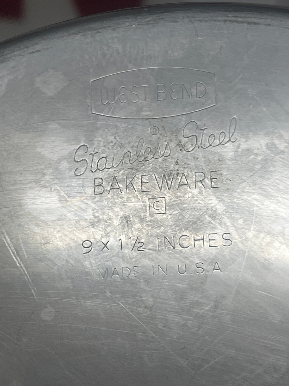 RARE Vintage West Bend Stainless Steel Round Baking Pans, set of 2, featuring close-up details of durable, heavy stainless steel surface with engraved lettering.