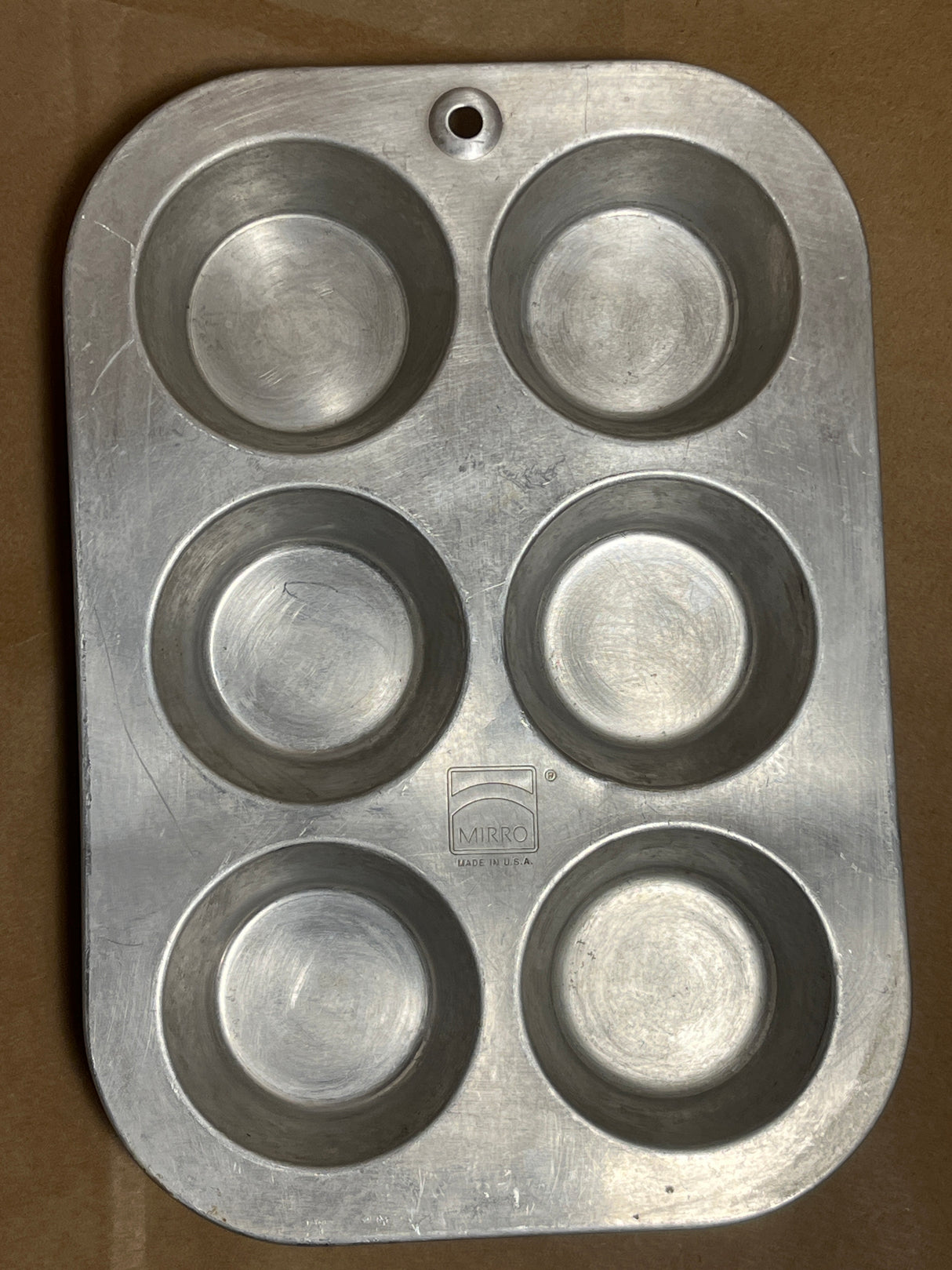 Mirro USA aluminum muffin cupcake pan with 6 2.5D holes, showcasing vintage charm and a well-worn patina, perfect for baking enthusiasts and collectors.