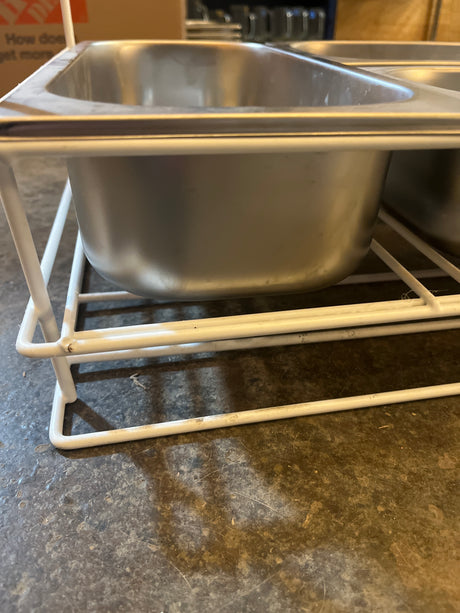 Set of 3 stainless steel steam pans with serving ring on a white wire rack, ideal for organizing kitchen prep or serving food at gatherings.