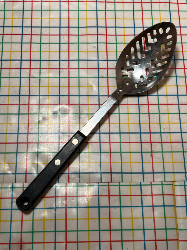 Slotted serving spoon - stainless steel with Bakelite handle - EKCO Forge, featuring a perforated bowl for efficient draining, displayed on a patterned surface.