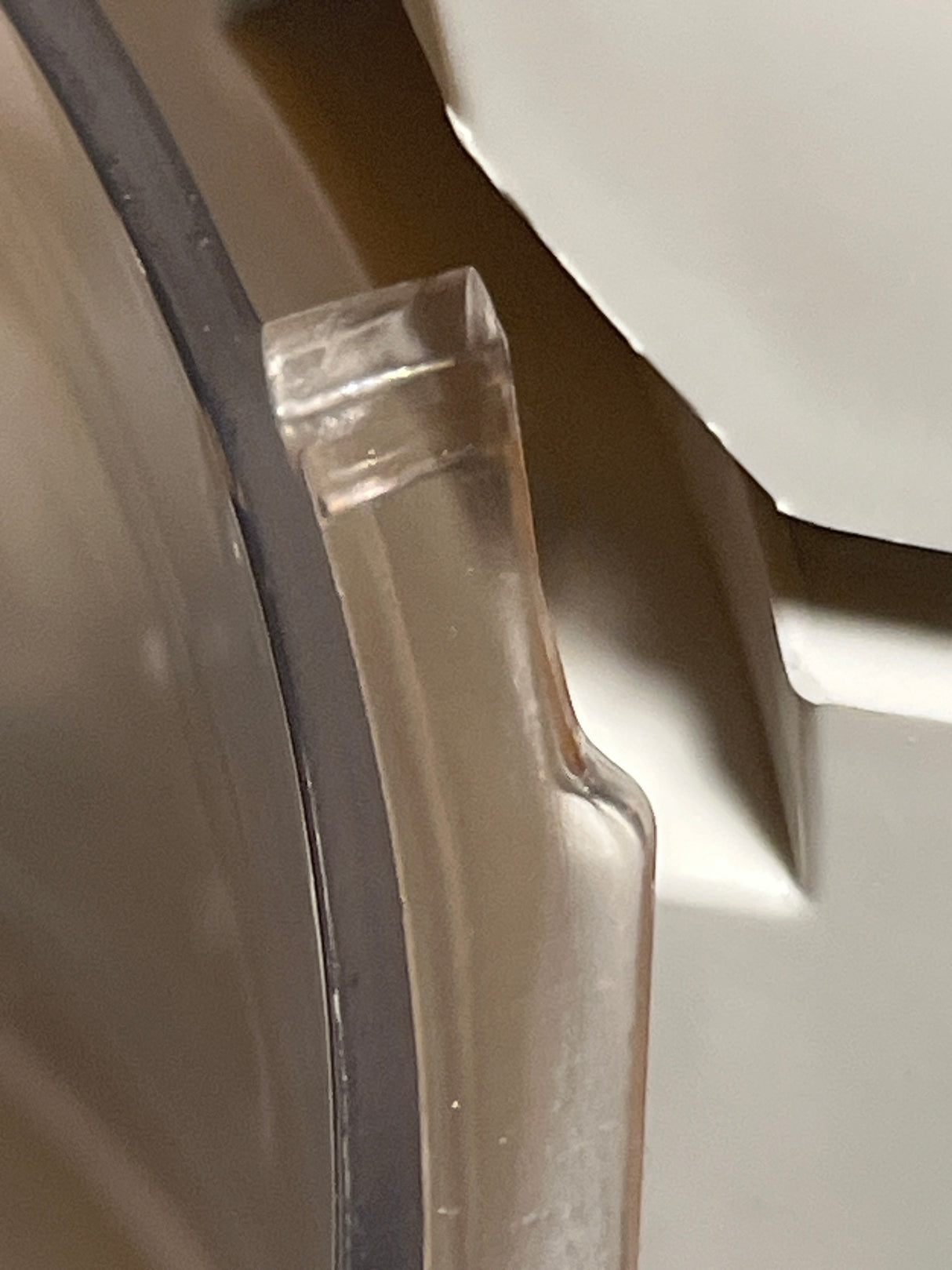 Close-up of Hamilton Beach Chef Prep 70700 food processor's plastic lid edge, showing molded latch and black gasket, highlighting a small chip that doesn't affect use.