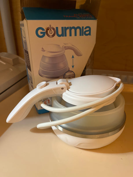 Gourmia folding travel kettle with a silicone base and stainless steel heating element, designed for compactness and quick boiling of up to 0.6 qt of water.
