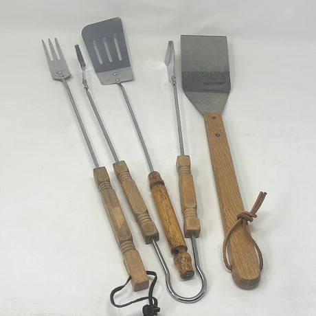 A 4-piece grill tool set featuring tongs, carving fork, lightweight spatula, and heavy-duty griddle spatula. Includes kitchen utensils and hand tools.