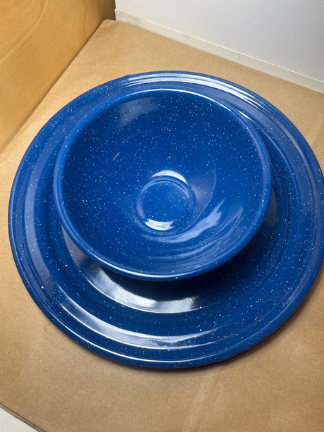 Blue speckled enamelware plate and bowl set with white flecks, ideal for snacks. Lightweight and durable, perfect for cookouts or camping.