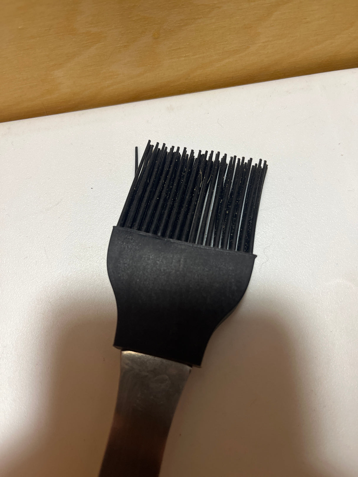 Silicone basting brush with metal handle featuring heat-resistant bristles, ideal for grilling, with a design that keeps hands safe from high heat.