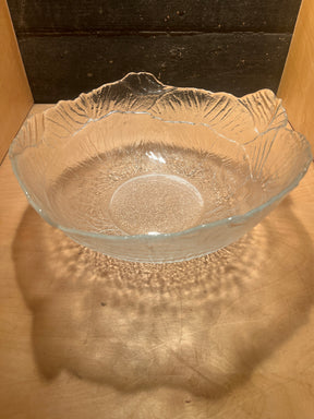 Viking 2408 cabbage 12 glass serving bowl with wavy, textured, clear glass, casting delicate shadow patterns on a wooden surface, ideal for springtime salad presentation.