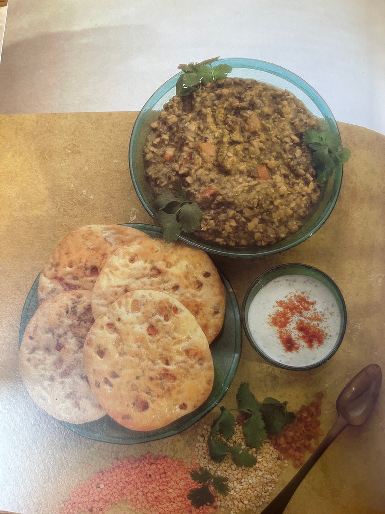 Indian Vegetarian Cookbook by Tarla Dalal showcasing a plate of food and a bowl of soup with a spoon, highlighting step-by-step illustrated recipes.