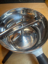 Stainless Steel Food Mill For Purees, Silver and White - OXO Good Grips, shown with crank handle and non-slip legs on a pot, ready for use.