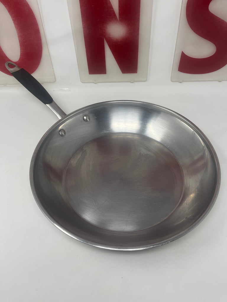 Calphalon heavy-duty 12-inch stainless steel frying pan with insulated handle, shown in close-up, highlighting its durable design and kitchen utility.