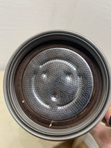 Close-up of a VEV Vigano Carioca 6-cup stainless steel espresso pot's perforated filter plate, showing coffee residue and old rubber gasket.