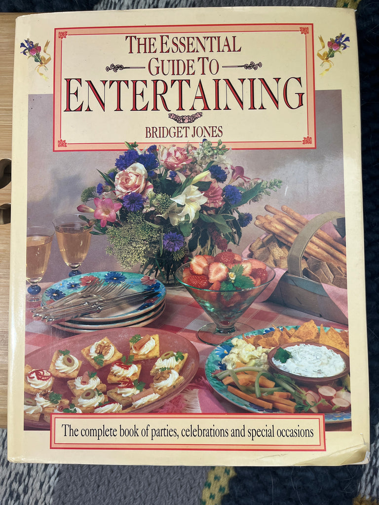 A book cover featuring a table set with food, flowers, and fruits, embodying The Essential Guide to Entertaining by Bridget Jones, offering entertaining ideas, seasonal menus, and decorative projects.