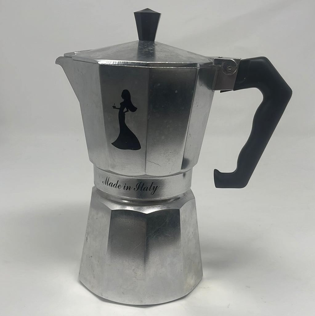 A silver 6-cup espresso pot from Italy with a black handle, featuring a mysterious lady logo. Minor stains from use. Product title: Che bella 6-cup espresso pot.
