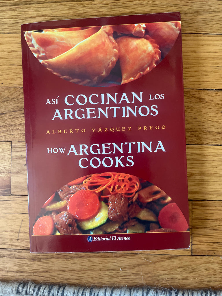 Cookbook Así Cocinan los Argentinos / How Argentina Cooks on a wooden surface, showcasing modern Argentine recipes and cooking techniques for effortless home cooking.