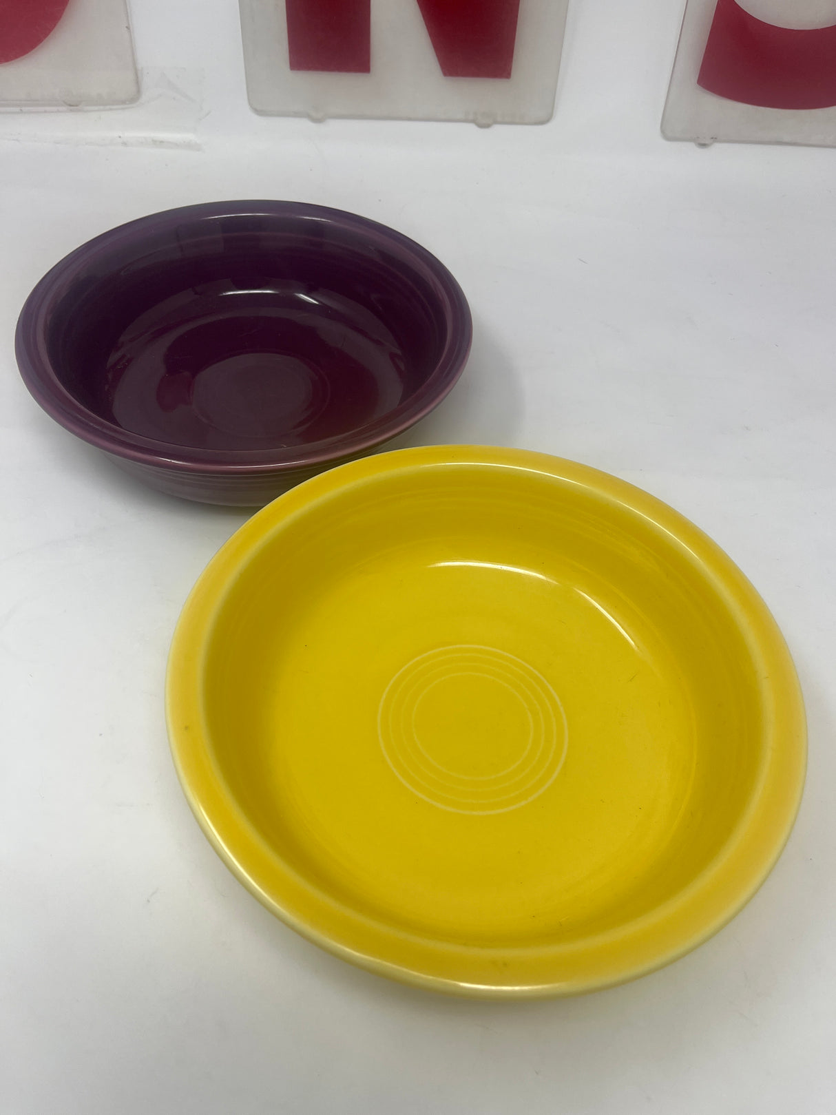 Fiestaware set of 2 soup/salad bowls, featuring a vibrant design with one purple and one yellow bowl, displayed on a white surface.