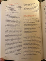 Martha Stewart’s Hors d’Oeuvres Handbook open to recipes for Carrot Cumin Canapés and Roasted Red Pepper Hummus Canapés, detailing ingredients and preparation steps.