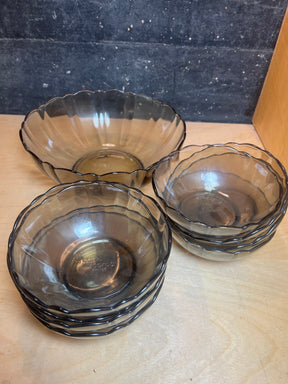 Arcoroc smoky glass set includes one large scalloped serving bowl and six smaller stacked dessert bowls, perfect for elegant dining presentations.